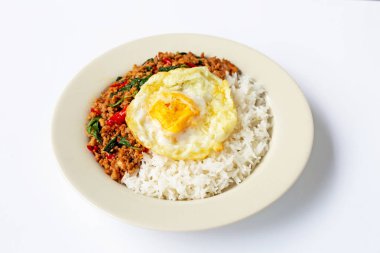 Pirinç fesleğen ve kızarmış yumurta ile tavada domuz eti ile tepesinde 