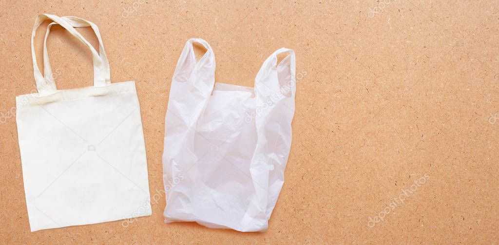 White fabric bag with white plastic bag on plywood background.