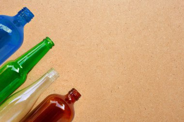 Kontrplak arka planda cam şişeler. 