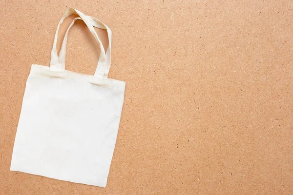 White fabric bag on plywood background.