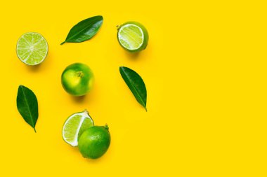 Sarı arka planda yapraklı kireçler. 