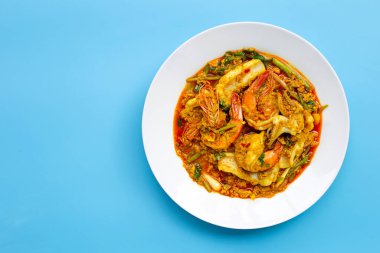 Mavi arka planda köri tozlu kızarmış deniz ürünleri. Boşluğu kopyala