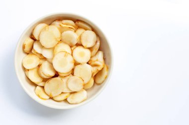 Beyaz arka planda izole edilmiş beyaz kasede taze galangal dilimler.