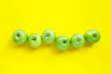 Sarı arka planda taze yeşil elmalar. Üst görünüm