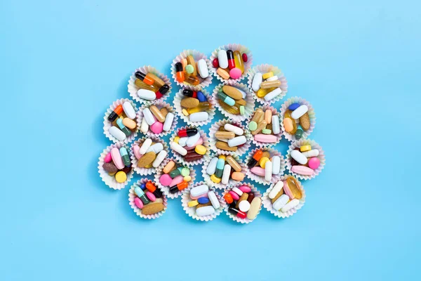 Kleurrijke Tabletten Met Capsules Pillen Cupcake Verpakkingen Blauwe Achtergrond — Stockfoto