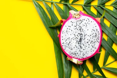 Olgun ejderha meyvesi ya da tropik palmiye yaprakları üzerinde pitahaya. Üst görünüm