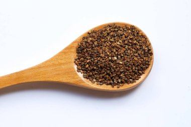 Beyaz arka planda tahta kaşıkta Gotu kola tohumları. 
