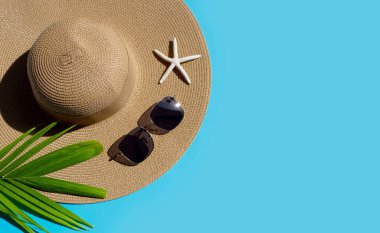 Mavi arka planda güneş gözlüklü yaz şapkası. Tatilin tadını çıkar. Boşluğu kopyala