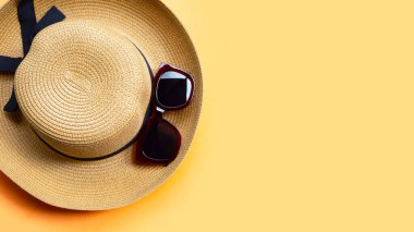 Turuncu arka planda yaz şapkalı güneş gözlükleri. Tatilin tadını çıkar. Boşluğu kopyala