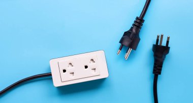 Elektrik kablosu ve fişi mavi arka planda. Üst görünüm