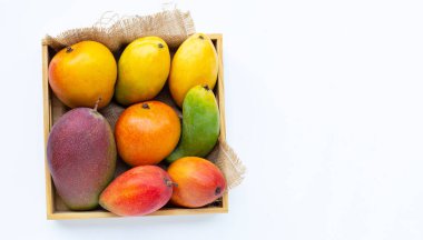 Tropik meyve, beyaz arka planda tahta kutuda mango. Üst görünüm