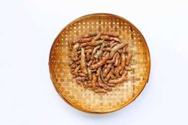 Beyaz arka planda ahşap bambu harman sepetinin zerdeçal kökleri. Boşluğu kopyala