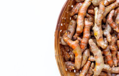 Beyaz arka planda ahşap bambu harman sepetinin zerdeçal kökleri. Boşluğu kopyala