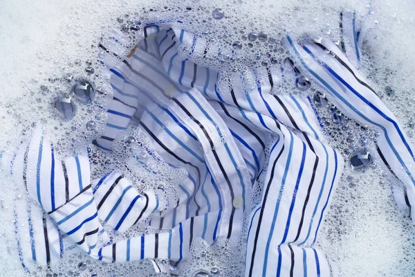 衣類のトップビューは 粉末洗剤水の溶解に浸かります ランドリーコンセプト — ストック写真