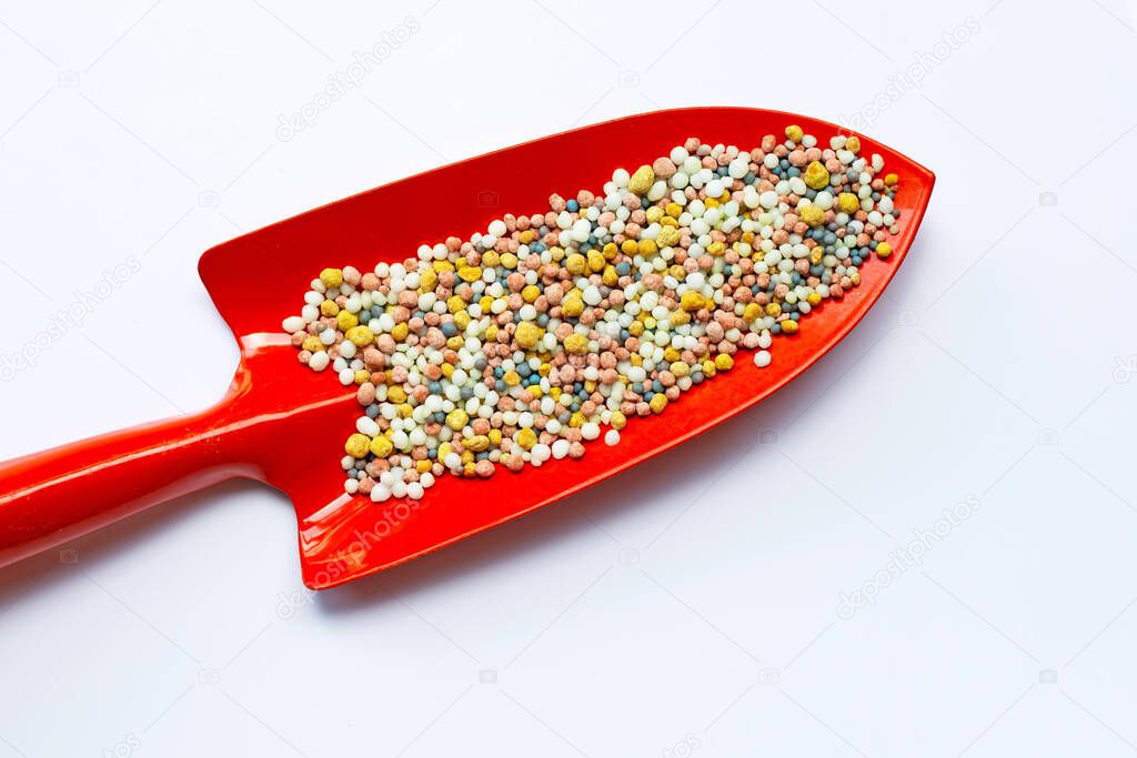 Colorful chemical fertilizer with garden trowel for planting and plantation.