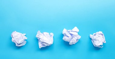 Mavi arka planda beyaz buruşuk kağıt top. Boşluğu kopyala