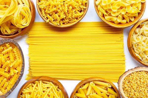 Beyaz zemin üzerinde farklı tipte kuru makarna