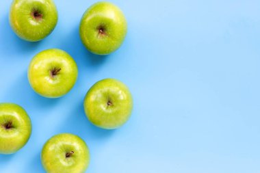 Mavi arka planda yeşil elmalar. Boşluğu kopyala