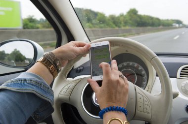 Bottrop, Almanya - 16 Ağustos 2018: tam hızlı bir karayolu üzerinde kullanıyor sarışın bir kadın whatsapping onun smartphone ise.