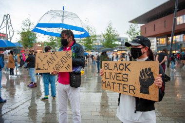 ENSCHEDE, NETHERLANDS - 05 Haziran 2020: Protestocular, George Floyd 'un öldürülmesini ve ABD' de ırkçılığı protesto etmek için Enschede 'nin göbeğindeki sağanak yağmurda gösteri yapıyorlar.