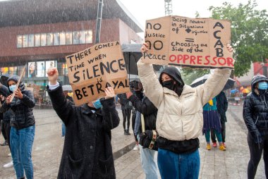 ENSCHEDE, NETHERLANDS - 05 Haziran 2020: Protestocular, George Floyd 'un öldürülmesini ve ABD' de ırkçılığı protesto etmek için Enschede 'nin göbeğindeki sağanak yağmurda gösteri yapıyorlar.