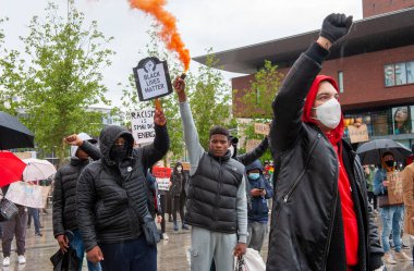 ENSCHEDE, NETHERLANDS - 05 Haziran 2020: Protestocular, George Floyd 'un öldürülmesini ve ABD' de ırkçılığı protesto etmek için Enschede 'nin göbeğindeki sağanak yağmurda gösteri yapıyorlar.