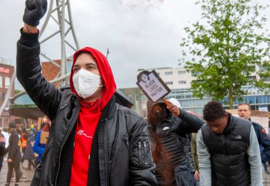 ENSCHEDE, NETHERLANDS - 05 Haziran 2020: Protestocular, George Floyd 'un öldürülmesini ve ABD' de ırkçılığı protesto etmek için Enschede 'nin göbeğindeki sağanak yağmurda gösteri yapıyorlar.