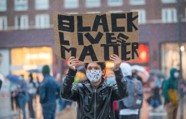 ENSCHEDE, NETHERLANDS - 05 Haziran 2020: Protestocular, George Floyd 'un öldürülmesini ve ABD' de ırkçılığı protesto etmek için Enschede 'nin göbeğindeki sağanak yağmurda gösteri yapıyorlar.