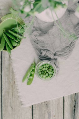 Çiçekli vazolarla servis edilen masa ve bir tabak bezelye