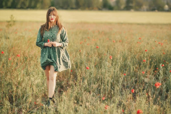 女の子で緑のドレスにギターでケシ畑 — ストック写真