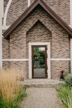 Çekici tuğla bina cephesi yemyeşil ve parlak beyaz kapılı