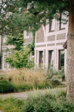 Çekici tuğla bina cephesi yemyeşil ve parlak beyaz kapılı