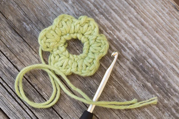 Crocheted Yellow Bloom Crochet Hook Wool Wooden Tablel — Stock Photo, Image