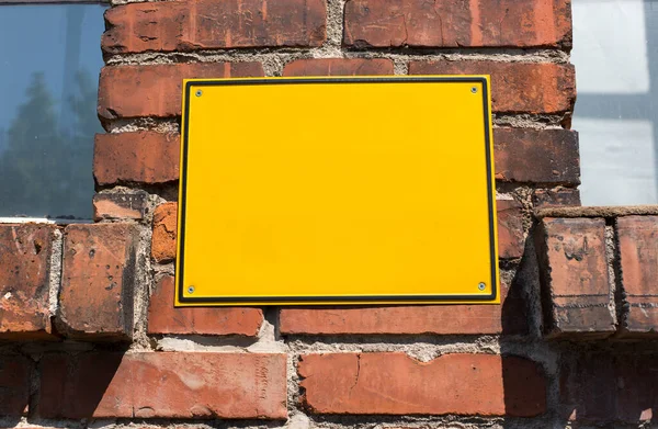Żółta Metalowa Tabliczka Starej Ceglanej Ścianie — Zdjęcie stockowe