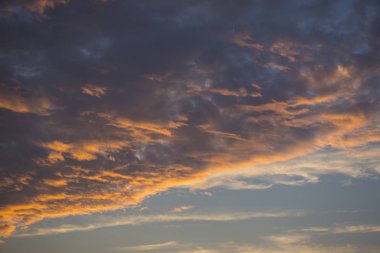Gün batımında bulutları olan güzel renkli bir gökyüzünün karesi.