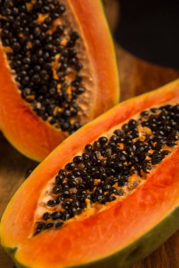 Ahşap zemin üzerinde bıçak olan Papaya taze kesiği. Dilimlenmiş papaya. Olgun papaya