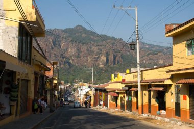 Tepoztlan, Morelos, Meksika - 2019: Şehir merkezinde arka planda tepozteco dağı olan bir sokak.