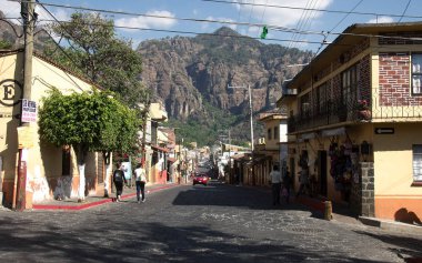 Tepoztlan, Morelos, Meksika - 2019: Şehir merkezinde arka planda tepozteco dağı olan bir sokak.