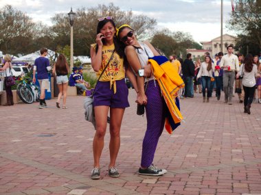 Baton Rouge, Louisiana, USA - 2018: Fans hold hands and smile at Louisiana State University during an LSU football game. clipart