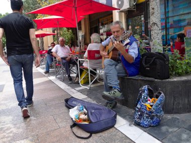 Cordoba, Arjantin - 2019: Bir adam şehir merkezinde bir yaya sokakta ipuçları için bir gitar çalar.