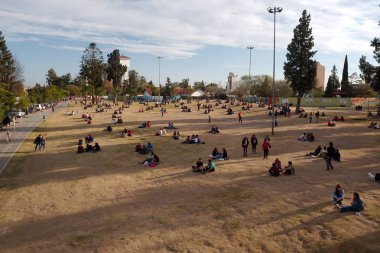 Cordoba City, Cordoba, Arjantin - 2019: İnsanlar (çoğunlukla üniversite öğrencileri) Cordoba Ulusal Üniversitesi yakınlarındaki Las Tejas Park'ta güzel bir kış akşamının tadını çıkarıyor. 