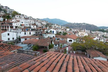 Taxco, Guerrero, Meksika - 2019: Kırmızı kiremit çatılı geleneksel beyaz evleri gösteren tarihi merkezin panoramik manzarası.