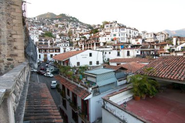 Taxco, Guerrero, Meksika - 2019: Kırmızı kiremit çatılı geleneksel beyaz evleri gösteren tarihi merkezin panoramik manzarası.