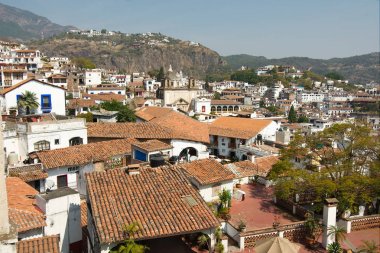 Taxco, Guerrero, Meksika - 2019: Kırmızı kiremit çatılı geleneksel beyaz evleri gösteren tarihi merkezin panoramik manzarası.