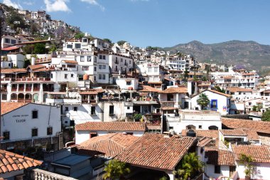 Taxco, Guerrero, Meksika - 2018: Kırmızı kiremit çatılı geleneksel beyaz evleri gösteren tarihi merkezin panoramik manzarası.