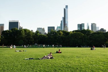New York City, New York, ABD - 2018: Central Park'ta insanlar güneşli bir yaz akşamının tadını çıkarıyor.