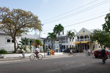 Key West, Florida, Usa - 2019: Bu küçük turistik kasabada alışılmış olduğu gibi insanlar şehir merkezinde güneşli bir günde bisiklete biniyor.