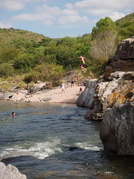 stock image Cuesta Blanca, Cordoba, Argentina - 2019: A man jumps from a rock into the San Antonio river, a popular tourist destination near the province capital.