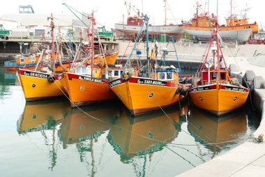 Mar del Plata, Buenos Aires, Arjantin - 2019: Şehir limanındaki geleneksel parlak turuncu balıkçı teknelerinin manzarası. 