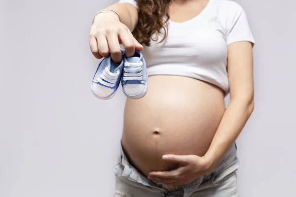 Gros Plan De La Femme Enceinte Avec Des Chaussures De Bebe Sur Le Ventre Soins Jeune Stock Photo Gros Plan De La Femme Enceinte Avec Des Chaussures De Bebe Sur Le Ventre Soins Jeune Stock Photo